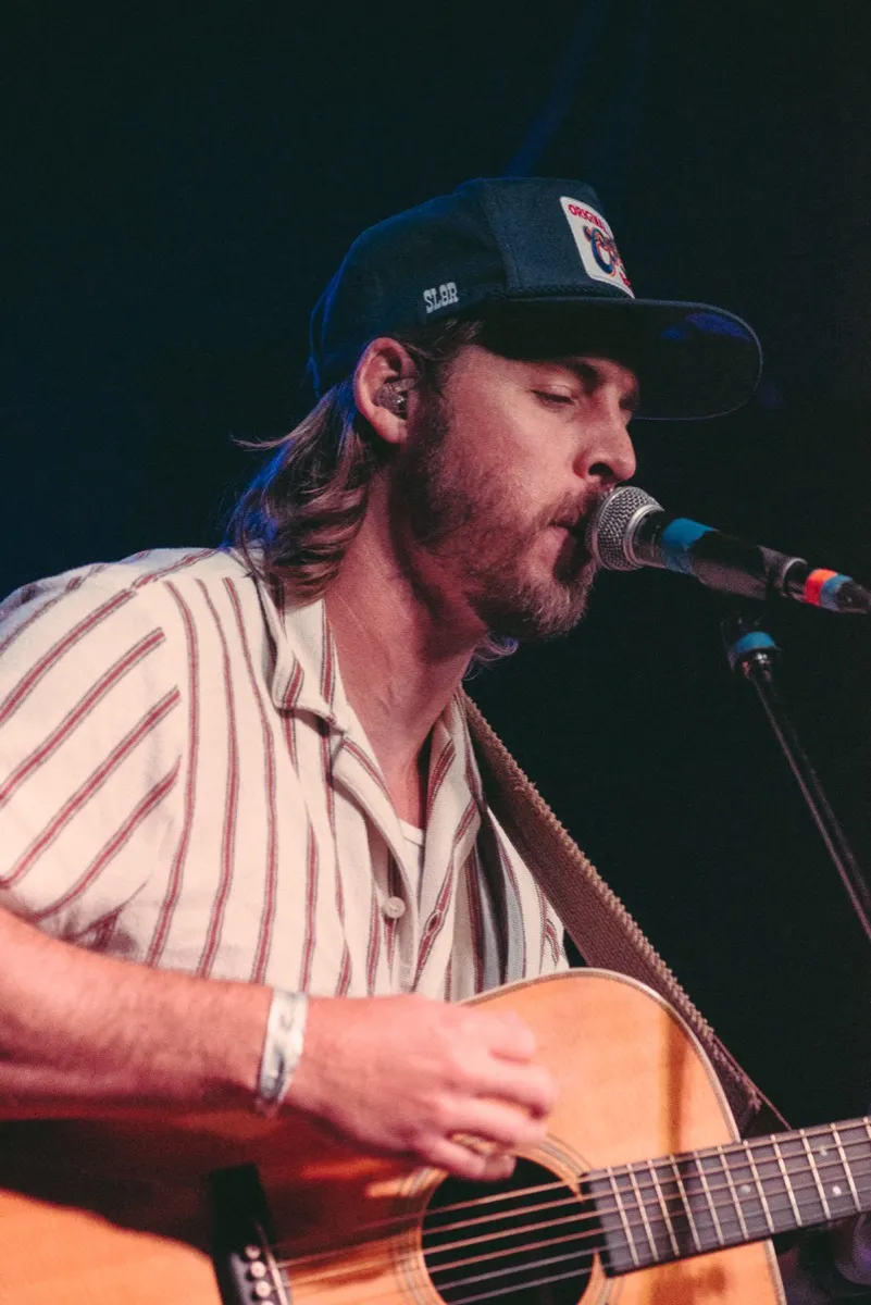 Big Holler's singer at the mic with an acoustic guitar